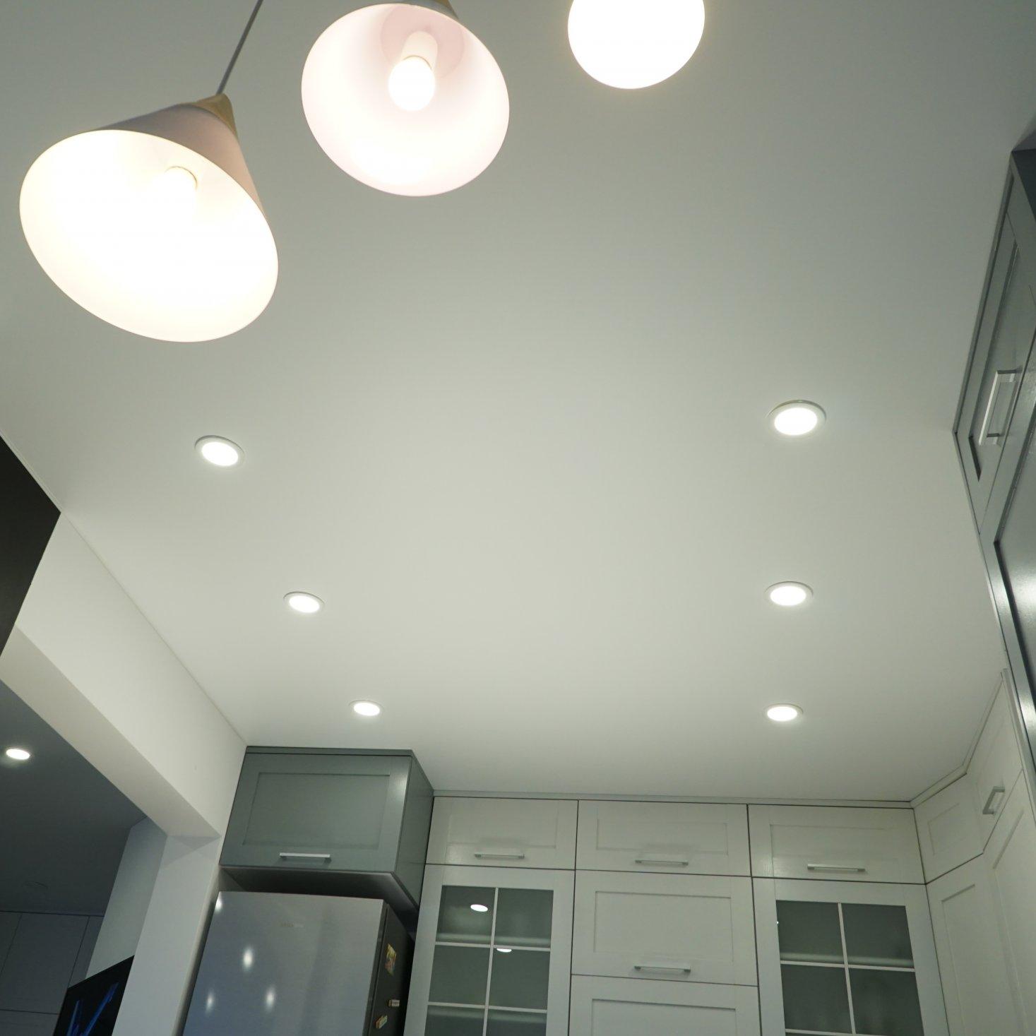 Тканевый потолок на кухне со светильниками и люстрами